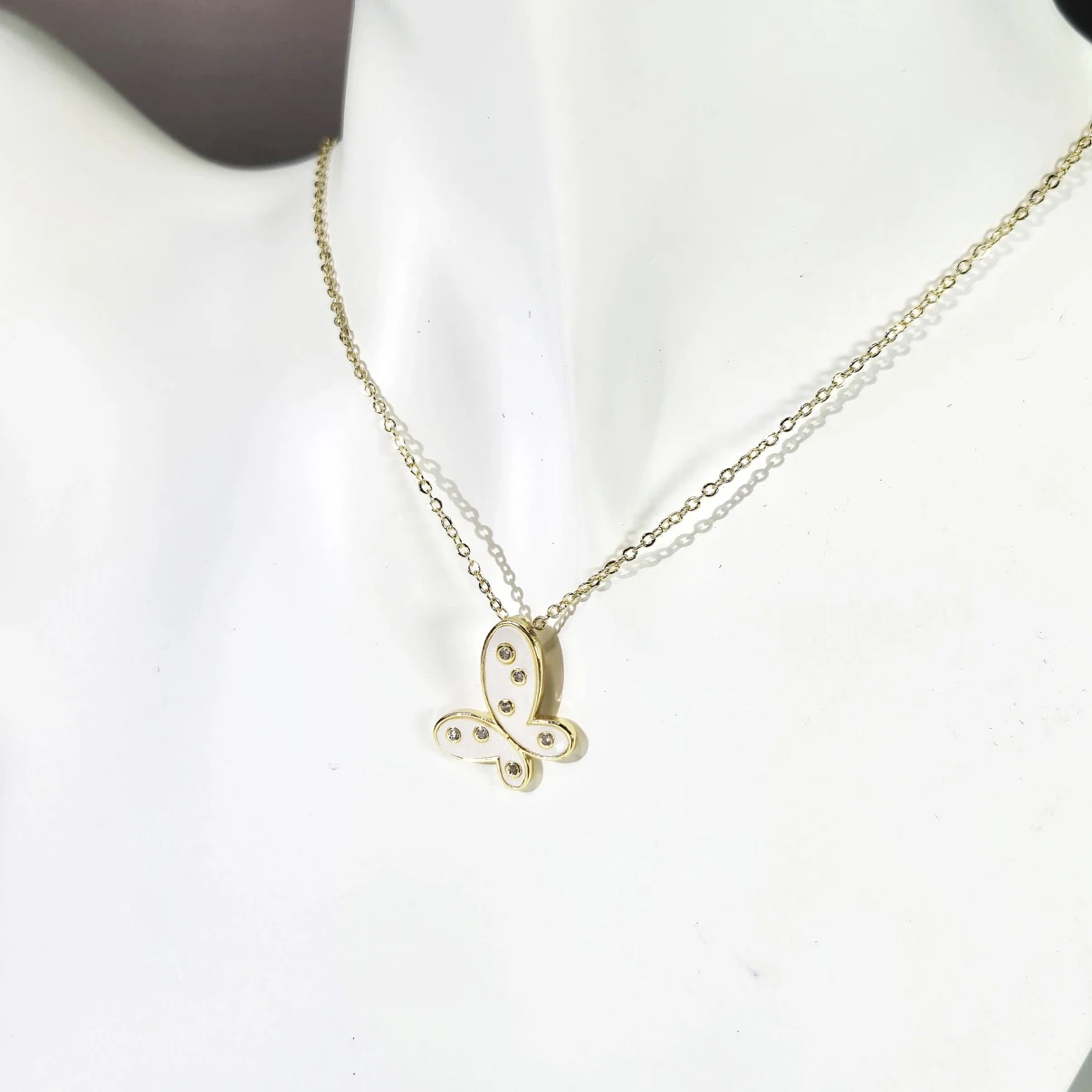 Gold butterfly necklace styled on display bust